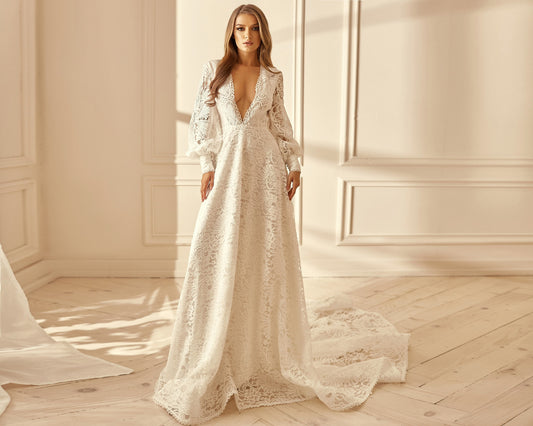 Bohemian wedding dress with long sleeves, deep V neckline and open back. The dress has dramatic train. Gown made from thick french lace white color.